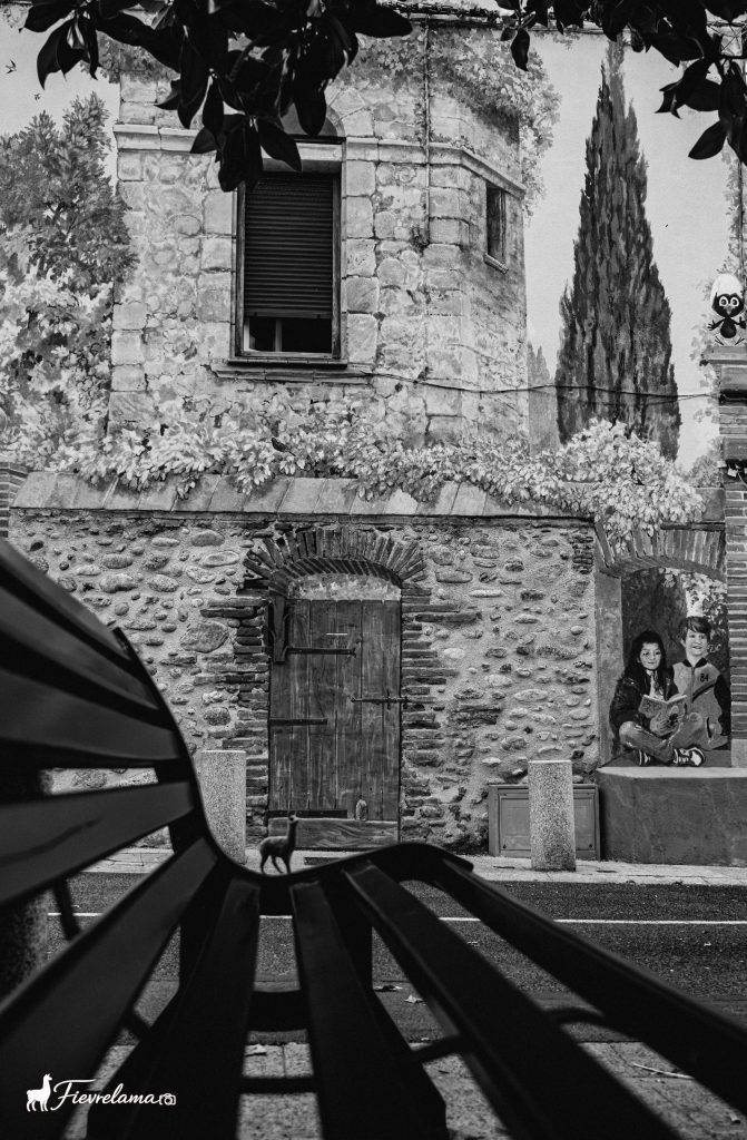 Façade de pierre ancienne encadrée de cyprès, photographie en noir et blanc