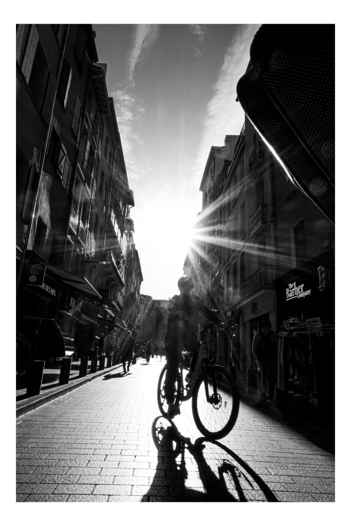 Rayon de soleil entre les façades d’une rue photographiée en noir et blanc